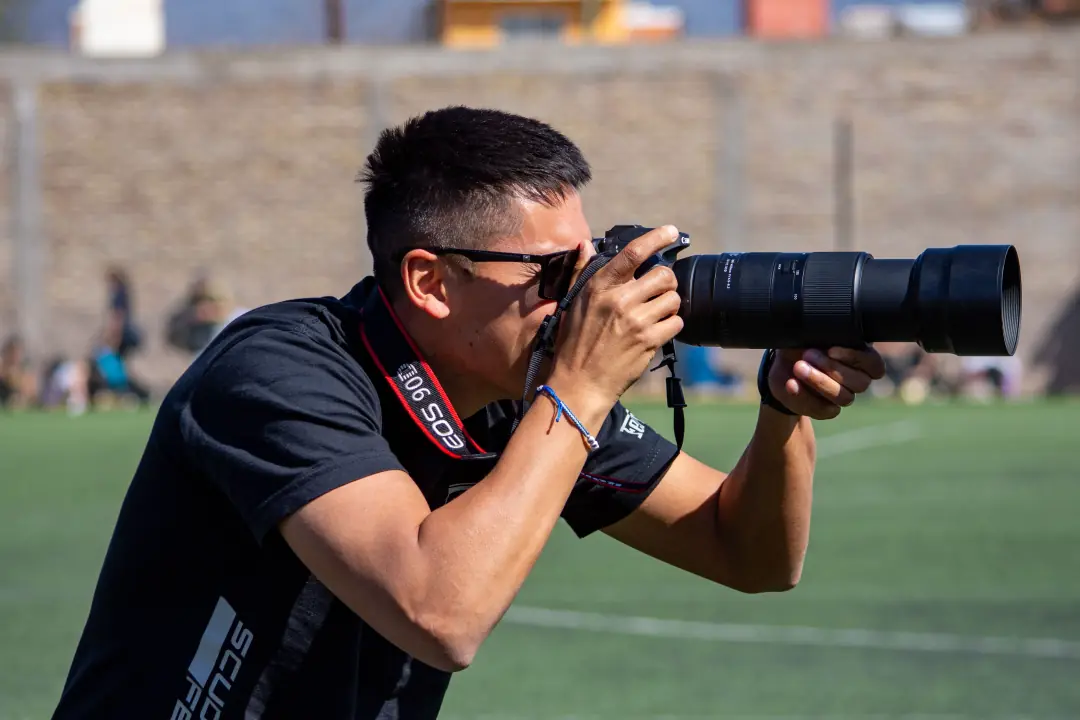 Photographer shooting with a telephoto lens at a game