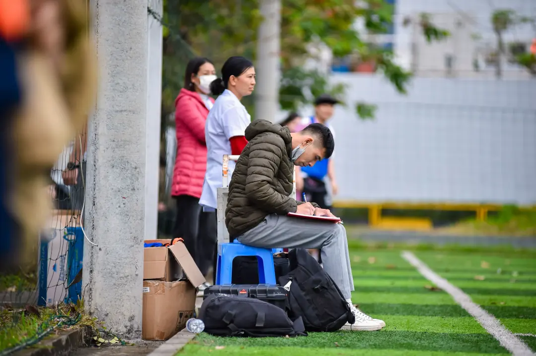 Person on the sideline taking notes during a match