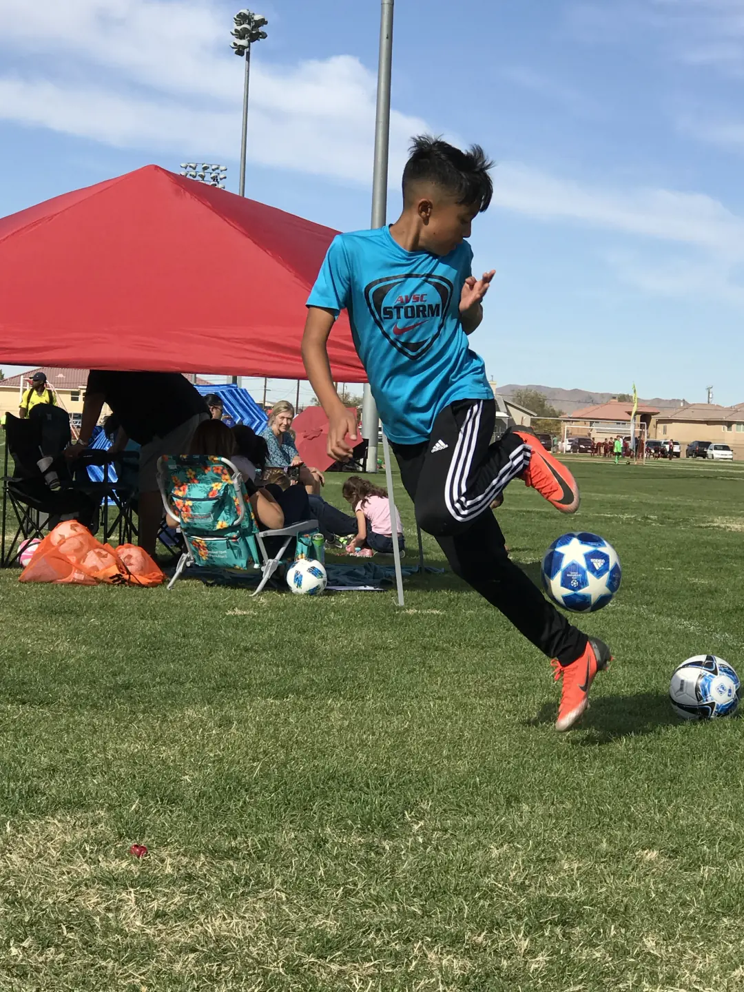 Young player dribbling a soccer ball at a tournament