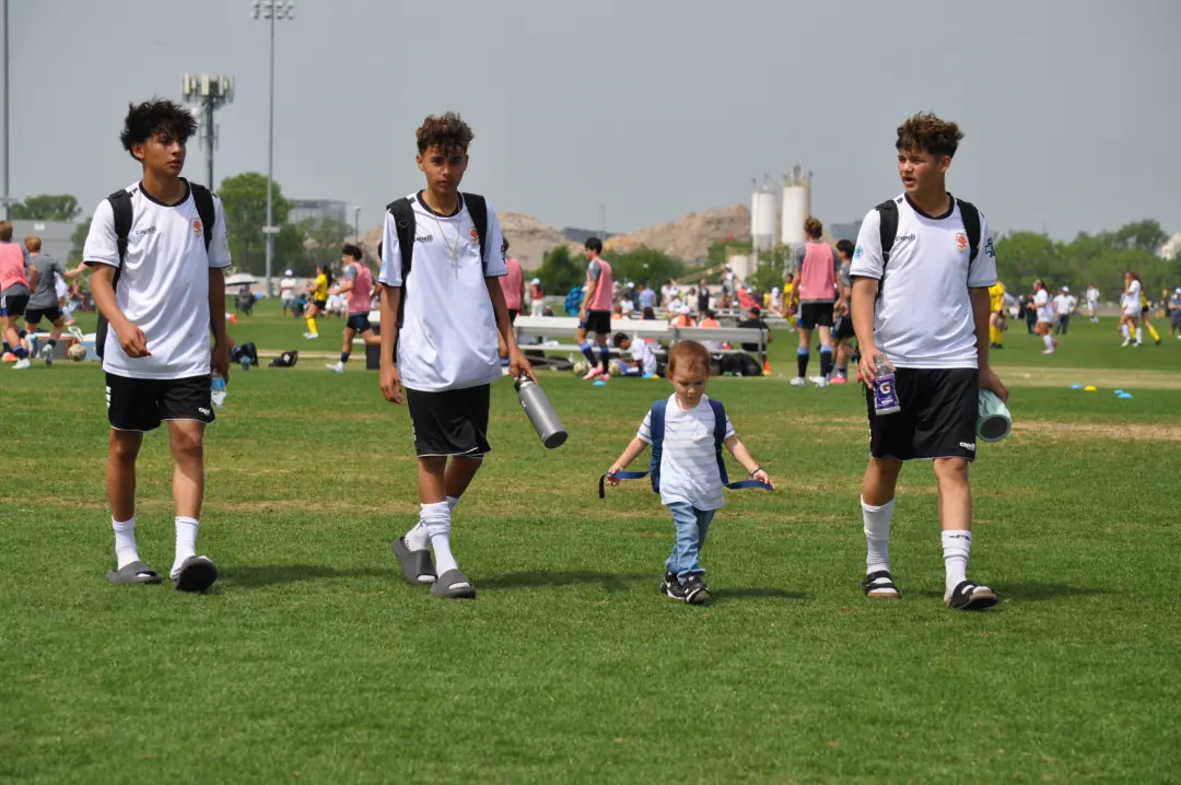 Teammates walking across the field with younger kids